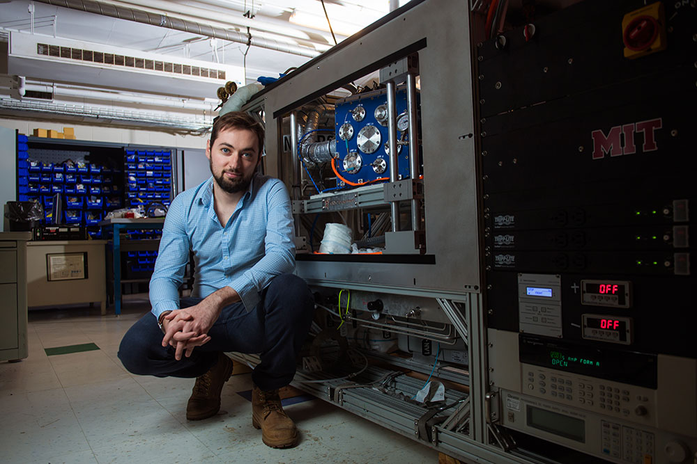 male in front of instruments in a lab at MIT