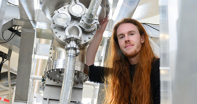 Graduate student, Thomas Varnish, in the middle of a research facility, PUFFIN at MIT's PSFC